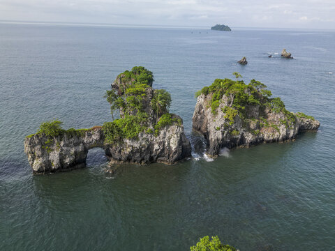 Aerial view of rugged Bota Island where verdant cliffs meet the endless blue expanse of the Limbe River, Limbe, South West, Cameroon.