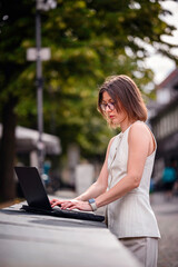 Focused Woman Working on Laptop in Historic Urban Setting