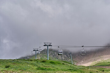 Cable car on foggy mountain slope at summer ski resort