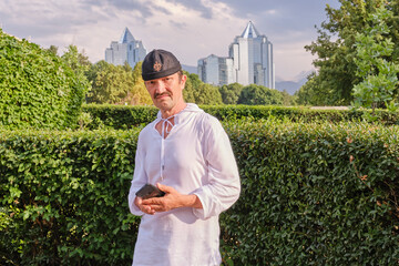 Man in traditional cap with modern cityscape of Almaty, Kazakhstan