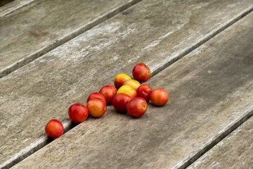 Fresh mirabelle plums scattered on rustic wooden table