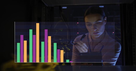 Reviewing data with stylus on tablet, woman wearing blouse at data center server racks, copy space