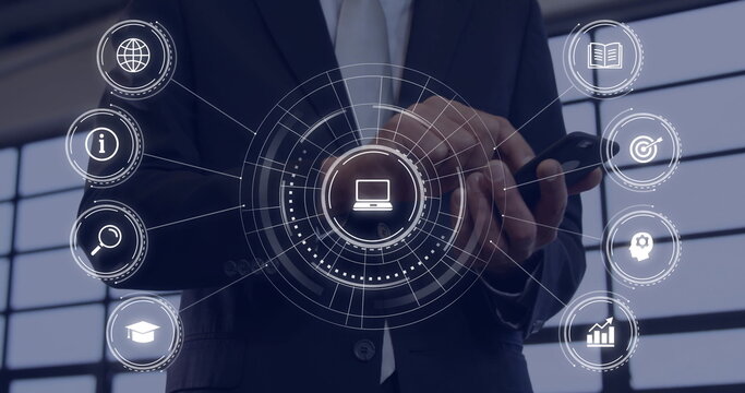Tapping smartphone businessman projecting interface near office windows, showing laptop plus icons