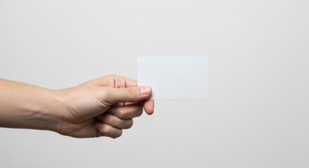 Close-Up of Hand Holding Blank White Credit Card on Minimalist Studio Background