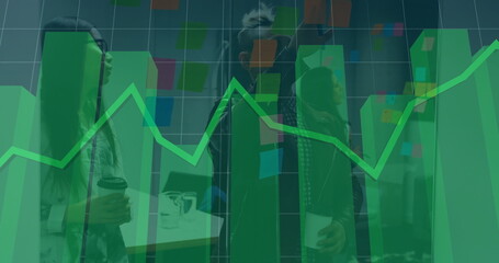 Collaborating team planning project in office with sticky notes on partition, laptop and data chart