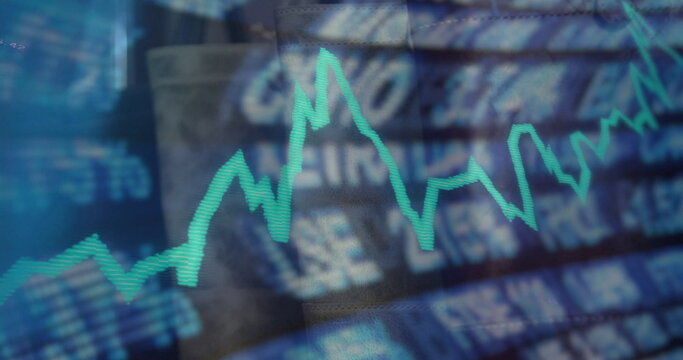 Displaying neon turquoise zigzag line chart on trading monitor, with blurred financial interface