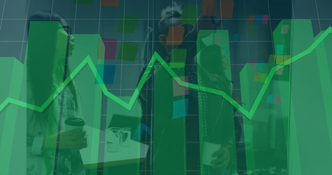 Collaborating team planning project in office with sticky notes on partition, laptop and data chart - Powered by Adobe