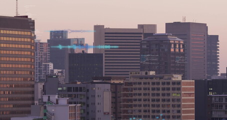 Displaying high-rise towers reflecting sunset glow at city skyline, with construction crane