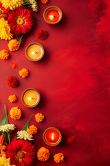 Lighted oil lamp with red and yellow flowers on red background. Traditional Indian Diwali festival decoration. Clay diya for festive celebration.