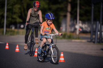 Child and Adult Biking Through Cones During Outdoor Practice