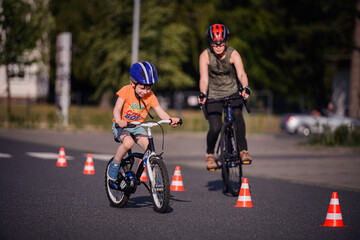 Child and Adult Biking Through Cones During Outdoor Practice