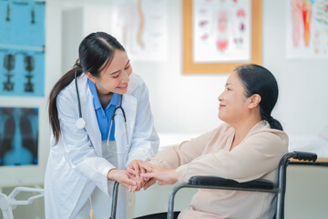 Fototapeta premium Smiling doctor provides compassion care for mature female patient in wheelchair during hospital recovery. Professional doctor offers medical assistance and support to elderly patient in modern health