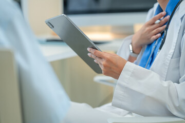 Female doctor examines patient using stethoscope in medical clinic. Professional nurse comforts...