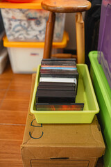 Collection of CD and DVD cases stored in a green plastic tray