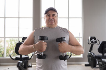 Man exercising in gym, lifting weight, lifting dumbbell equipment. Mature male workout dumbbell in gym. Fitness, gym and exercising