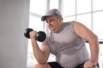 Man exercising in gym, lifting weight, lifting dumbbell equipment. Mature male workout dumbbell in gym. Fitness, gym and exercising