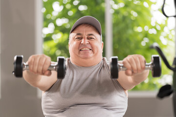 Man exercising in gym, lifting weight, lifting dumbbell equipment. Mature male workout dumbbell in gym. Fitness, gym and exercising