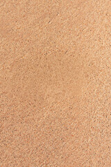 Fine textured beach sand surface in warm natural light