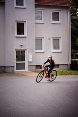 Girl Riding Red Bicycle Through Residential Street Curve