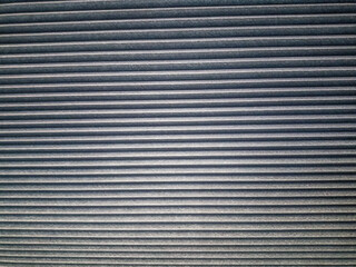 Horizontal blind texture with dark gray color, giving a modern and industrial impression.

