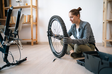 sports lady securing bicycle wheels for outdoor cycling. woman adjusting bike tire at home