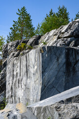 Bizarre patterns of marble on huge stones in old quarries overgrown with pines in the Ruskeala Mountain Park in Karelia