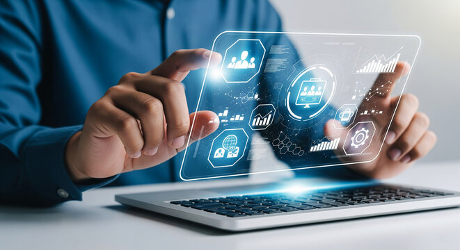 Person interacts with a transparent digital interface above laptop, showcasing data analysis, business management, and technology integration, symbolizing modern workflow and digital solutions