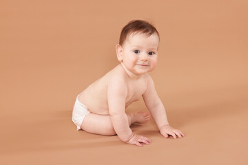 Cute little baby crawling on beige background