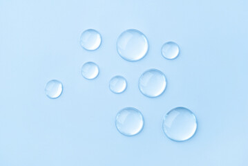 Transparent drops of cosmetics on a blue background