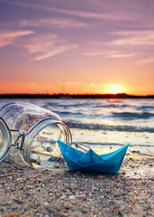 Anchored Ashore: A Blue Paper Boat Beside an Open Glass at Autumn Sunset