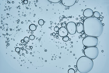 The texture of the serum is in the form of a drop on a blue background.