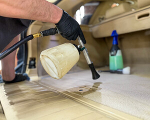 The process of professional detailing dry cleaning of the interior of the car using chemistry and tornado air gun. Dry cleaning of the car interior. The detailing master cleans the car interior. 