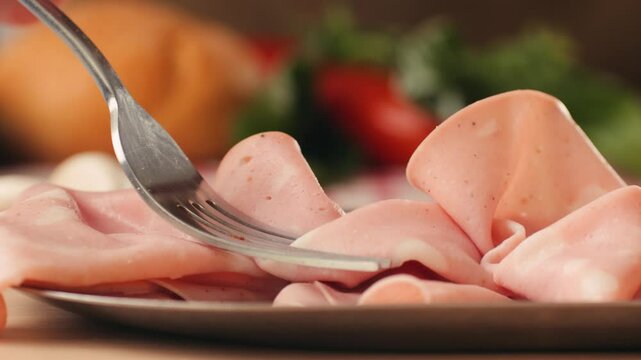 Ham italian mordatella, man Slices Of Traditional Italian antipasti mortadella sausage on a wooden cutting board, close up macro of chicken or turkey jamon, fat breakfast dish.