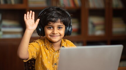 Boy with headphones waving in front of computer. Engaged learning experience in home environment. Cheerful student participating in video call.