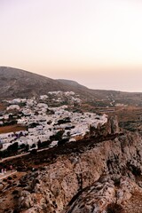 Naklejka premium Cliffside View of Traditional Whitewashed Village in Folegandros at Sunset