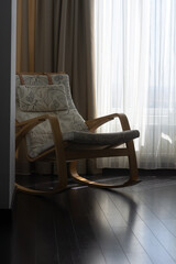 Rocking chair. Wooden rocking chair with soft cushions with minimalistic linear nature pattern