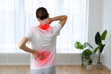 Woman experiencing upper back neck and lower back pain discomfort and stiffness