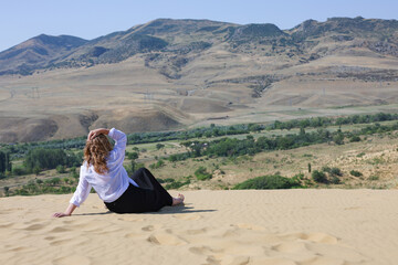Woman in the Sarykum dune in Dagestan. Travel, natural sightseeing tour . Reserve barkhan Sarykum in Dagestan. Mood to travel. Travel across Russia. Dunes