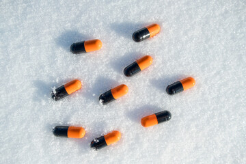 A group of pills are scattered on the snow