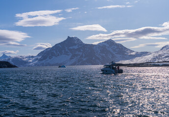 Iceberg tour power boat on fjord near the capital city of Nuuk with Sermitsiaq in background