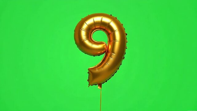 Golden number nine foil balloon floats against a vibrant green screen backdrop, ideal for celebrations and announcements.