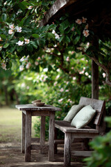 Obraz premium serene garden setting featuring wooden ethnicstyle furniture beautifully arranged among vibrant green foliage