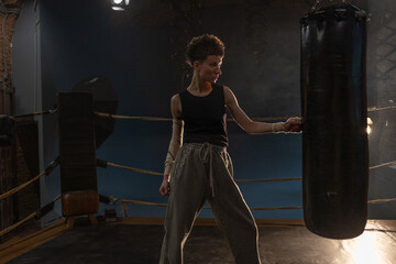 Boxing with a punching bag, sports achievements concept, female wrestler in a boxing ring,...