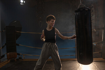 Boxing with a punching bag, sports achievements concept, female wrestler in a boxing ring,...