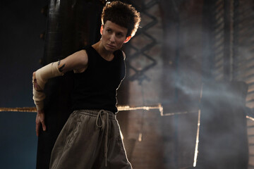 A female boxer with short hair and a black T-shirt. athletic appearance, pause after an intense...