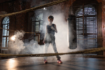 Boxing with a punching bag, sports achievements concept, female wrestler in a boxing ring,...