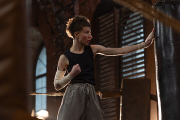 Woman boxer in ring with cinematic lighting, throwing powerful punch during intense training