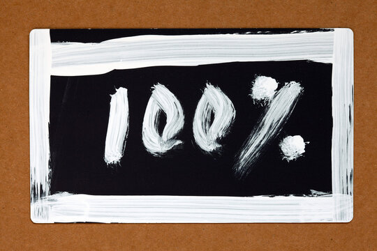a simple hand-drawn sign or label with "100%" written in  in   casual, handwritten style with white  paint, or marker.