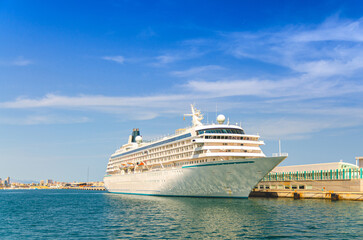 Grand cruise ship moored near pier in harbor Port of Alicante seaport, Cruise Liner docked, white...