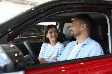 Happy family sitting inside new car. Luxury vehicle